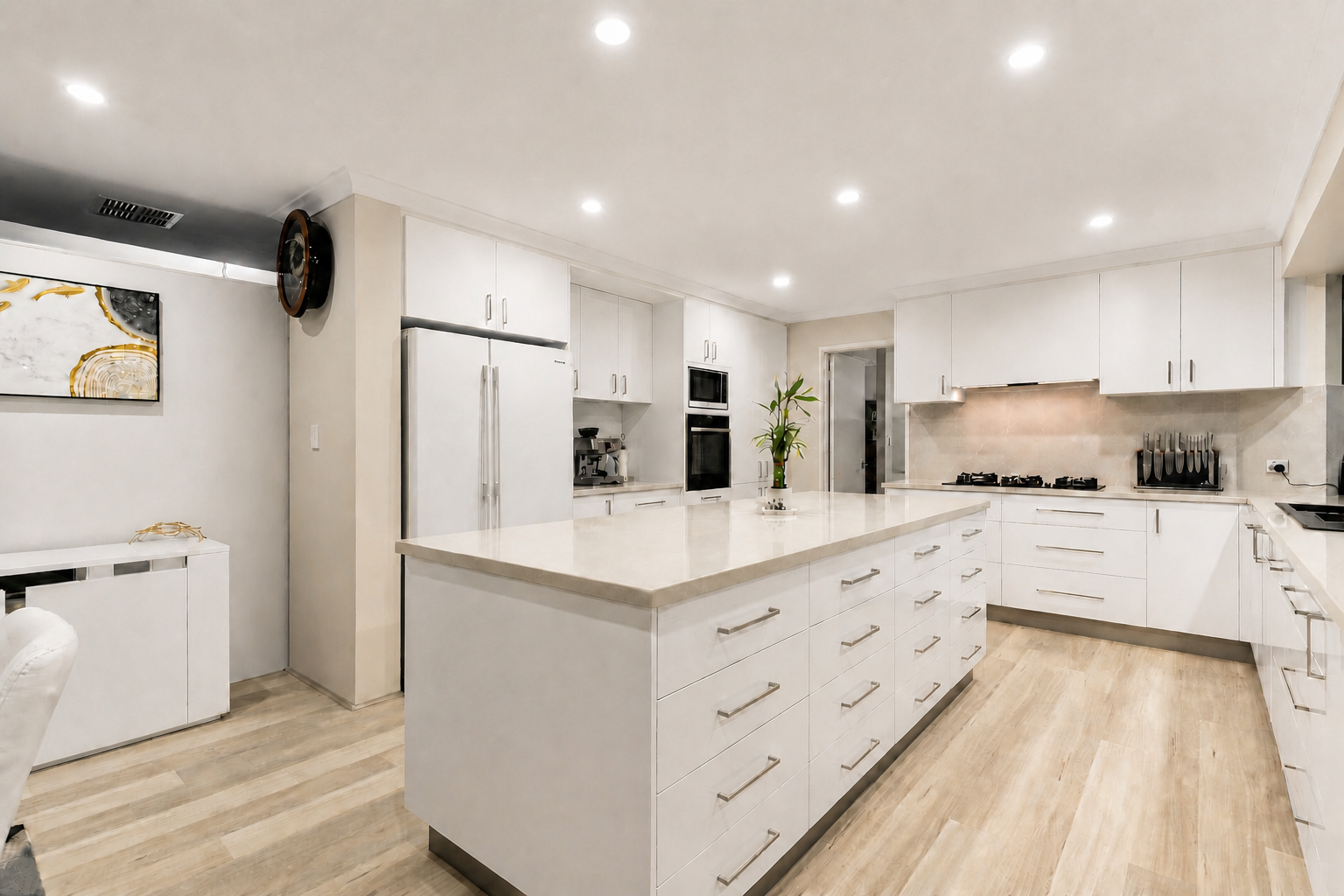 Bright open kitchen with low-sheen white painted cabinetry and a large central island