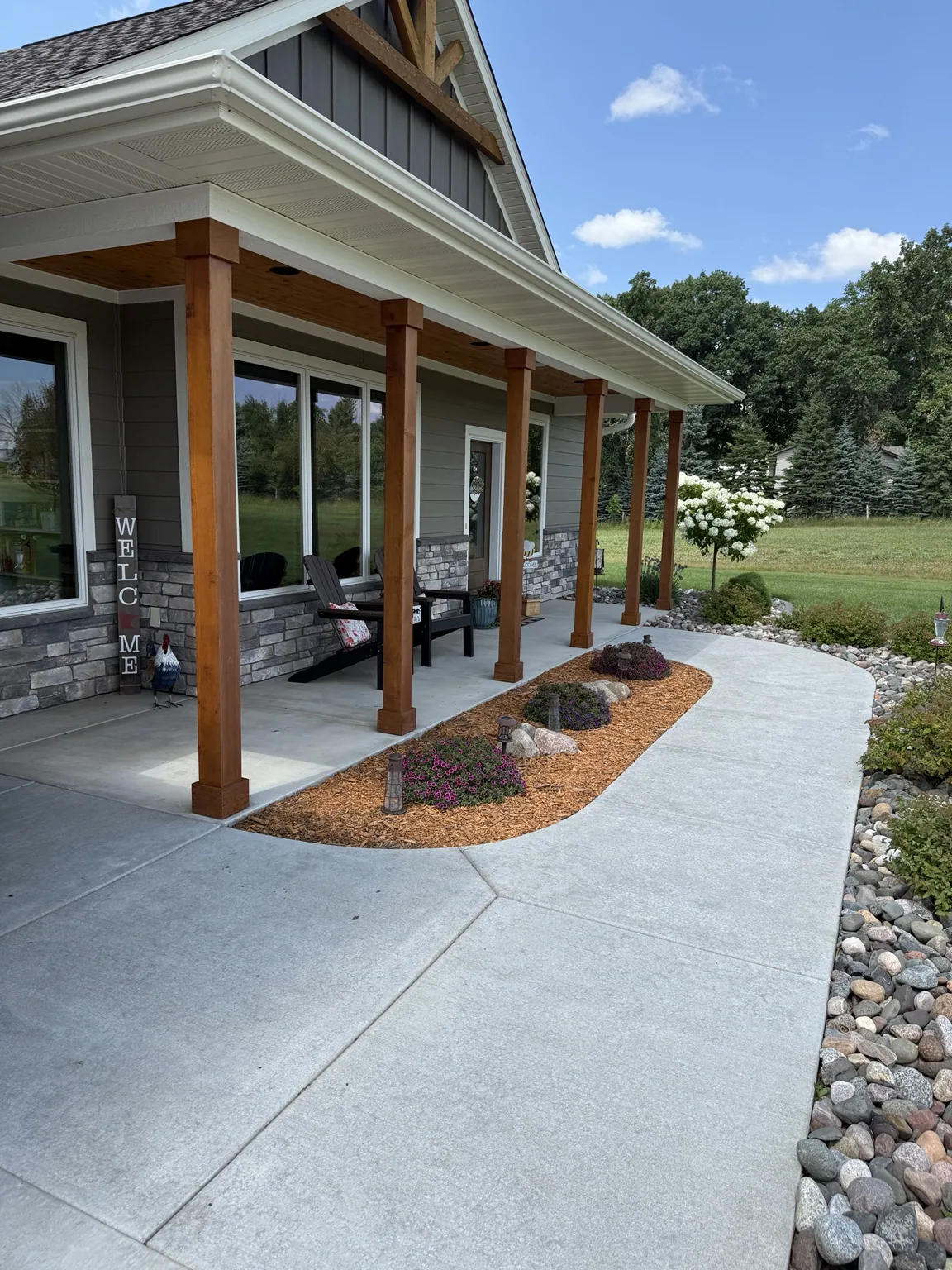 Finished front porch with wood posts, gray siding, and white trim.